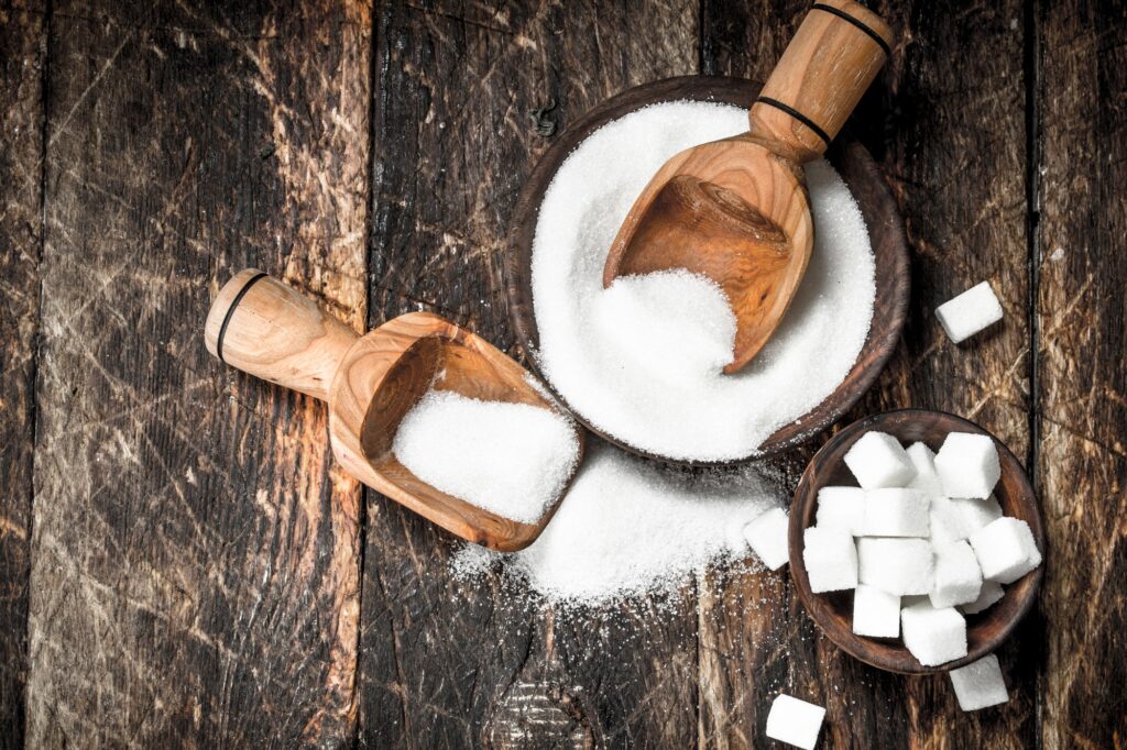 Sugar with a scoop in a bowl.