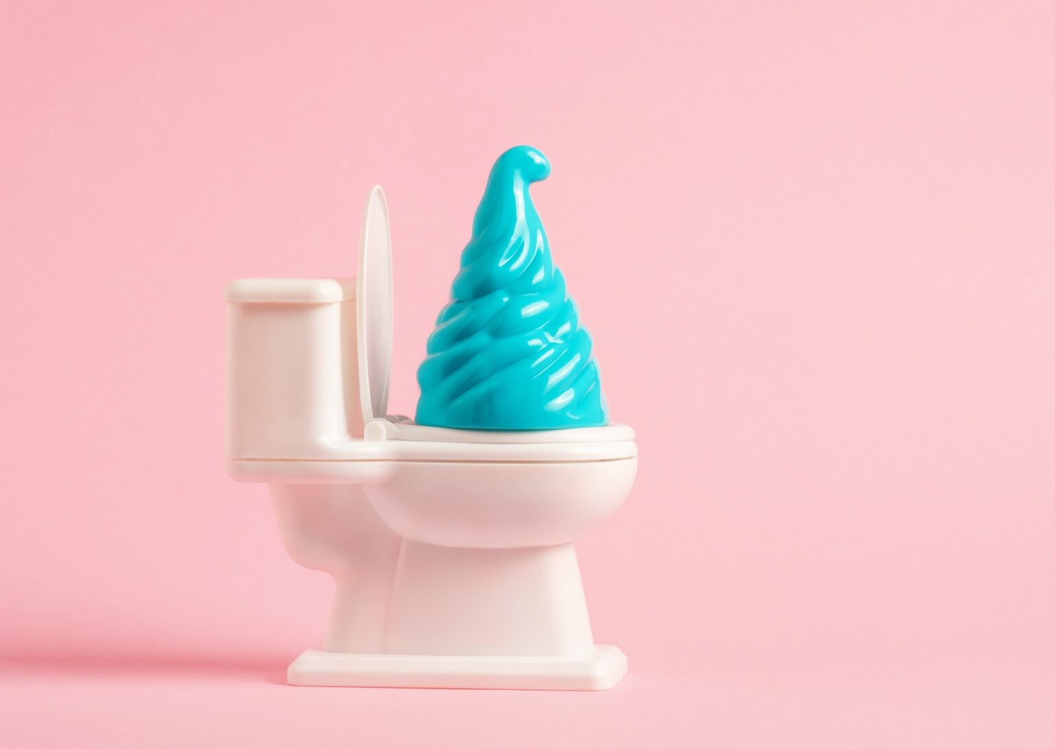 Toilet bowl with blue swirl on a pink background.